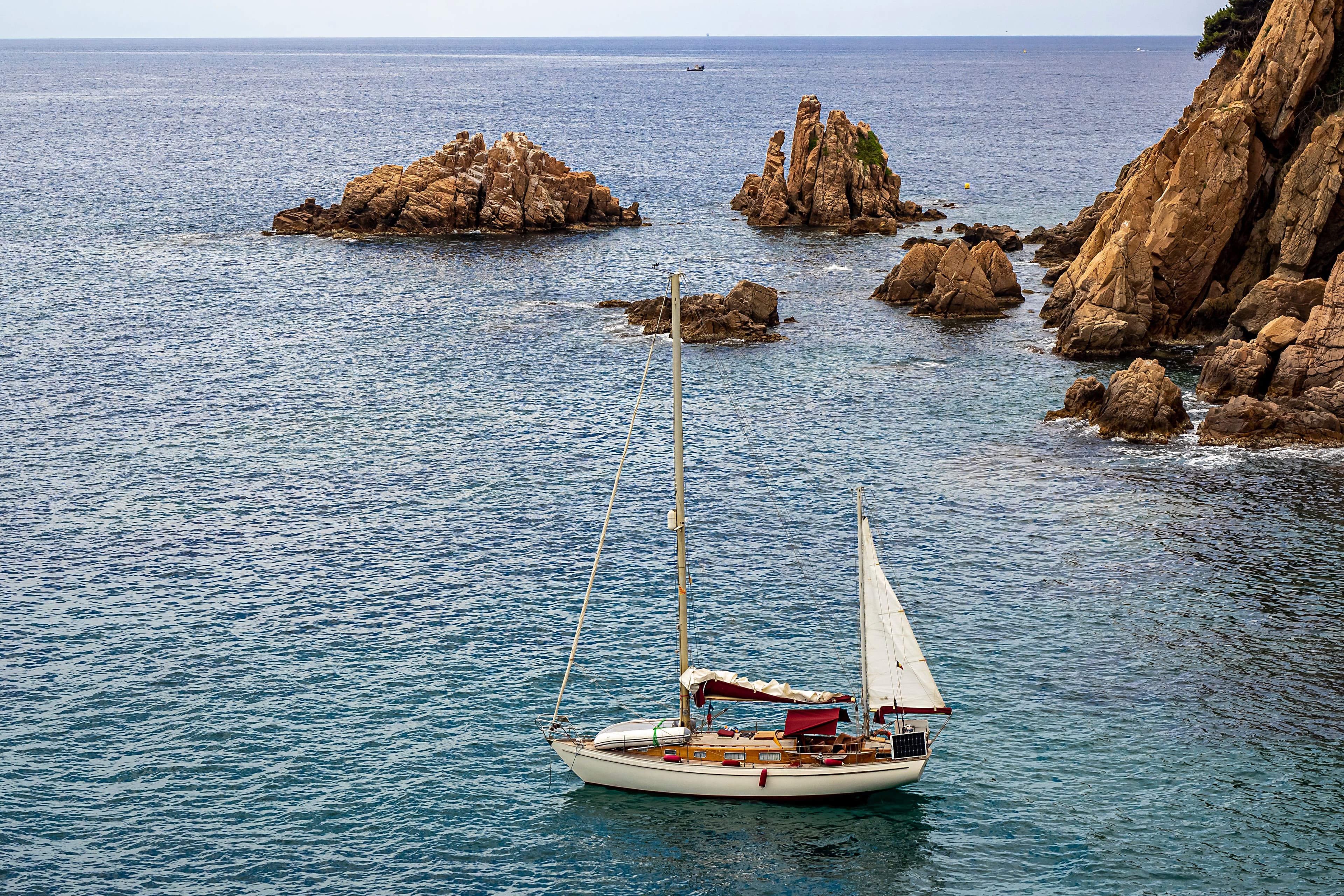 Velero frente a las rocas de la costa de Blanes